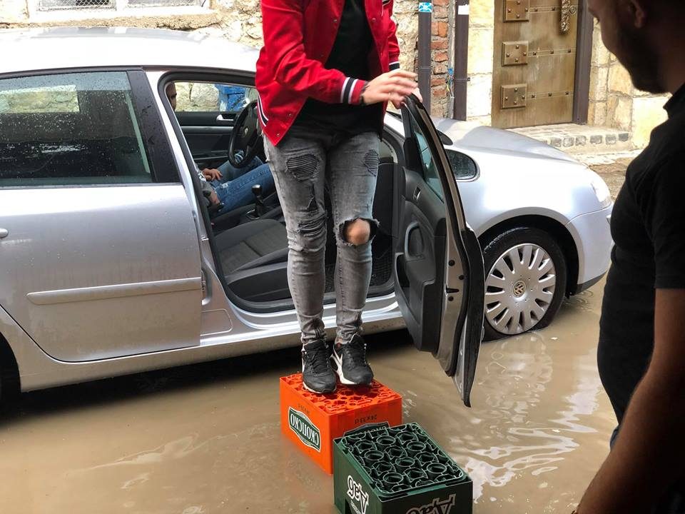 ФОТО: Охриѓани газат на гајби за да поминат низ поплавените улици